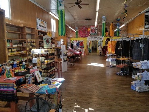 A vibrant store interior filled with colorful merchandise, including crafts, clothing, and local products on display.