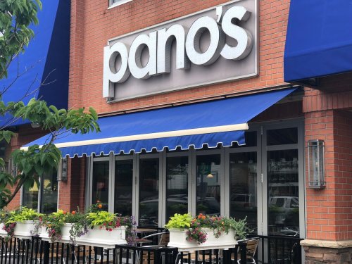 Exterior of Pano's restaurant featuring a blue awning and flower planters along the entrance.