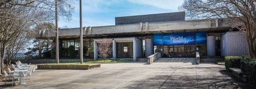 Exterior view of the World of Energy building, featuring a modern design and outdoor seating area.