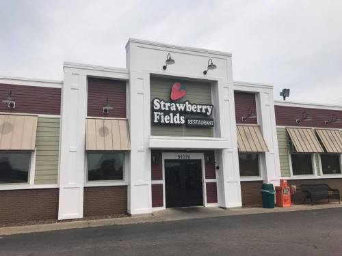 Exterior of Strawberry Fields Restaurant, featuring a sign, awnings, and a welcoming entrance.