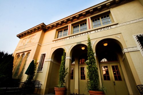 Exterior view of Kennedy Elementary School, featuring arched doorways and decorative architectural details.