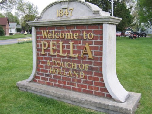 Welcome sign for Pella, Iowa, featuring brick design and the text "A Touch of Holland," established in 1847.
