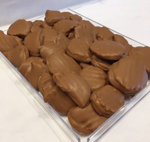 A clear container filled with various chocolate-covered candies, showcasing different shapes and sizes.