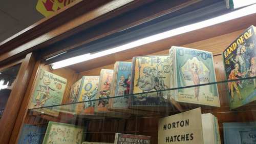 A display case featuring vintage Oz-themed books, including "Tik-Tok of Oz" and "The Lost Princess of Oz."