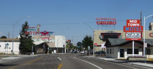 A street view featuring motels and a casino, with bright signage and clear blue skies.