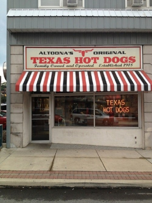 Sign for "Altoona's Original Texas Hot Dogs" with a red and white striped awning, showcasing a family-owned establishment.