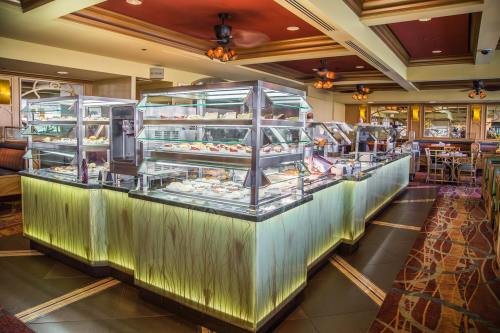 A buffet display with various food items in glass cases, illuminated by soft lighting in a restaurant setting.