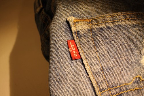 Close-up of a Levi's tag on a pair of faded blue denim jeans.