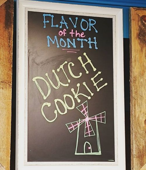 Chalkboard sign reading "Flavor of the Month: Dutch Cookie" with a colorful windmill illustration.
