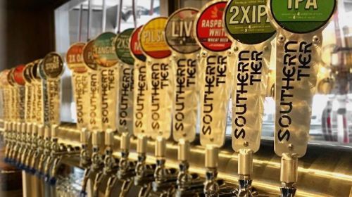 A row of beer taps with colorful labels showcasing various Southern Tier brews.
