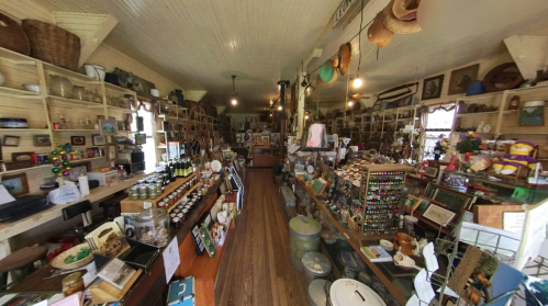 A cozy antique shop filled with various vintage items, jars, and crafts lining the shelves and tables.