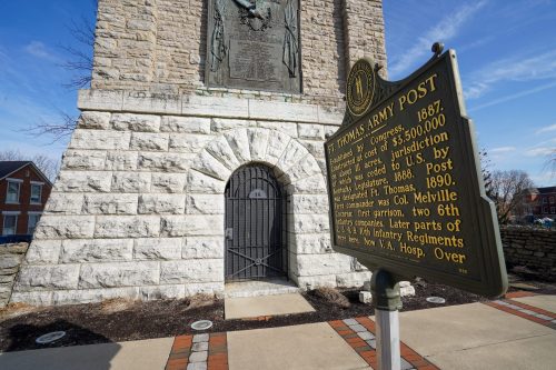 Historical marker for Fort Thomas Army Post, featuring stone structure and plaque, with a door in the background.