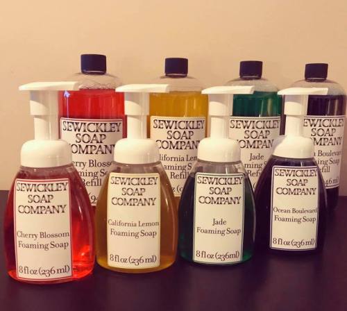 A collection of colorful foaming soap bottles from Sewickley Soap Company, featuring various scents and refill options.