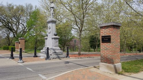 Entrance to Voctangee Park featuring a monument and stone pillars with a sign. Trees and greenery surround the area.