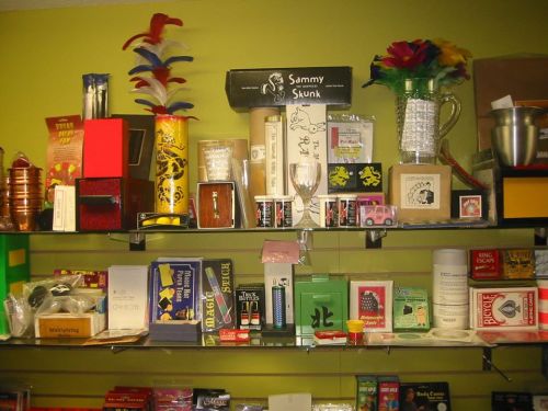 A colorful display of various novelty items and collectibles on shelves against a green wall.