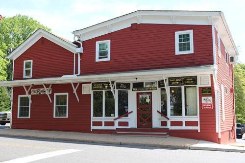 Red two-story building with white trim, featuring large windows and a welcoming entrance.