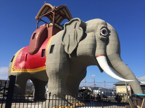 A large, colorful elephant-shaped building with a tower on its back, set against a clear blue sky.