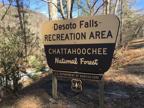 Sign for Desoto Falls Recreation Area in Chattahoochee National Forest, surrounded by trees and nature.