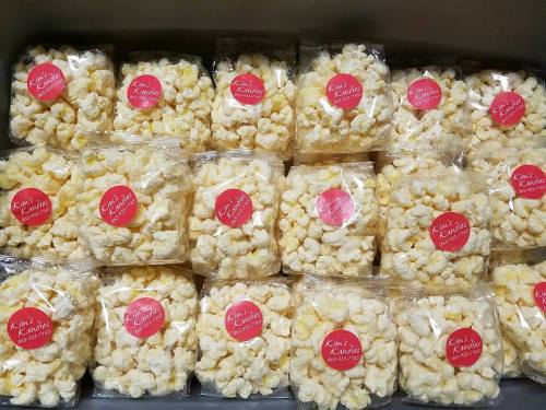A display of individually packaged popcorn bags with a red label reading "Kim's Kettle Corn."