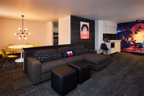 Modern living space featuring a cozy sectional sofa, dining area, and colorful wall art. Bright and inviting atmosphere.