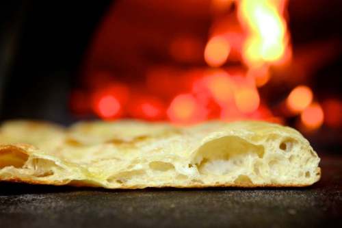 Close-up of freshly baked bread with a soft texture, set against a warm, glowing fire background.