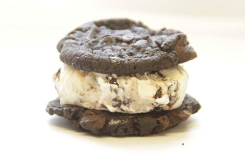 A chocolate cookie sandwich filled with vanilla ice cream and chocolate chips.