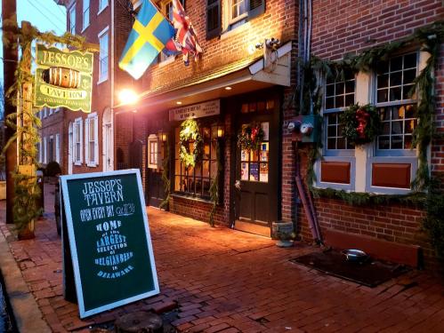 Exterior of Jessop's Tavern, featuring festive decorations, a sign, and brick pathways in a charming historic setting.