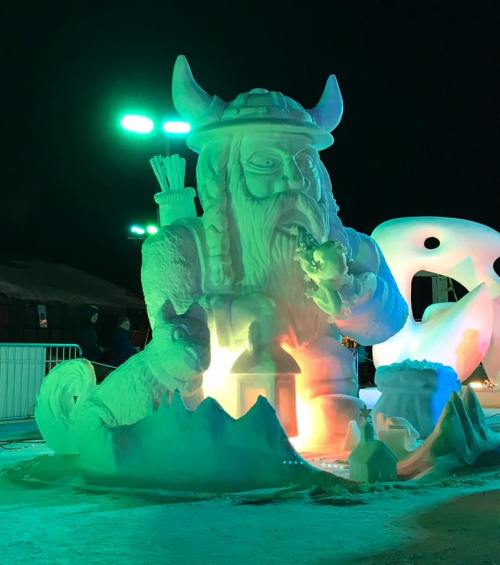 A large, illuminated ice sculpture of a Viking with a horned helmet, surrounded by smaller ice figures and decorations.