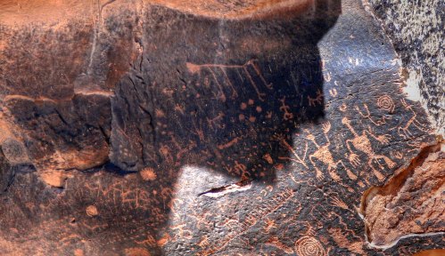 Ancient petroglyphs etched into a rocky surface, featuring various symbols and figures.