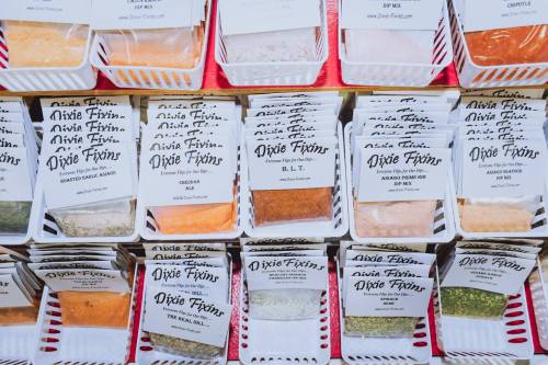 A display of various spice packets labeled "Dixie Fixins," featuring flavors like B.L.T. and ranch.