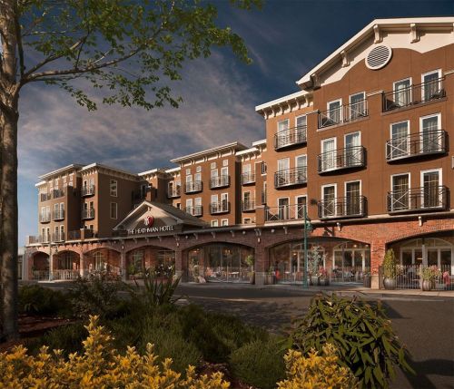 Exterior view of The Hermann Hotel, featuring a modern design with balconies and landscaped surroundings.