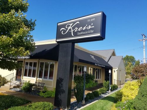Exterior of Kreis Steakhouse & Bar, established in 1948, featuring a sign and well-maintained landscaping.