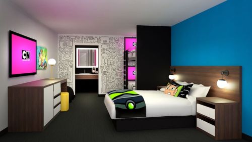 A colorful hotel room featuring a bed, TV, and playful decor with cartoon-themed elements on the walls.