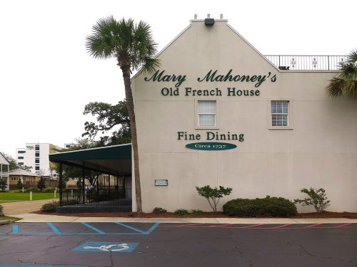 Sign for Mary Mahoney's Old French House, featuring "Fine Dining" and "Circa 1737," with palm trees in the background.
