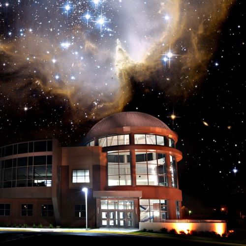 A modern building under a starry sky filled with galaxies and cosmic clouds, creating a stunning celestial backdrop.