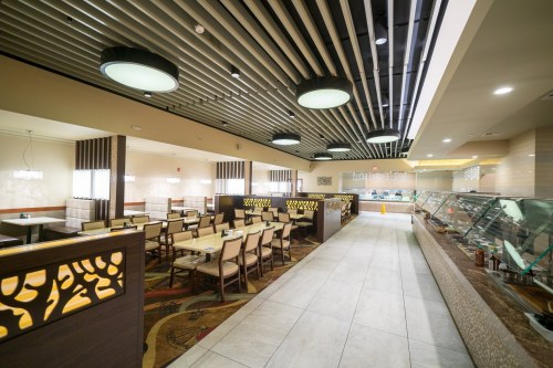 Interior of a modern restaurant featuring stylish seating, decorative partitions, and a well-lit dining area.