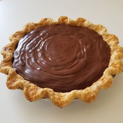 A freshly baked chocolate pie with a golden, flaky crust and a smooth, glossy chocolate filling.