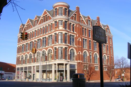 Historic brick building with a distinctive architectural design, featuring large windows and a sign for Lime Town Square.
