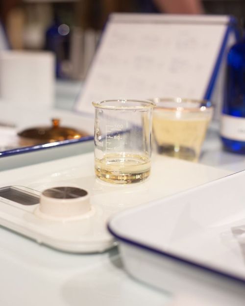 A laboratory setup featuring a beaker with liquid, a scale, and various glassware on a table.