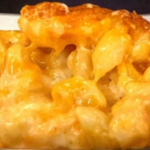 Close-up of creamy, cheesy macaroni and cheese with a golden, crispy top.