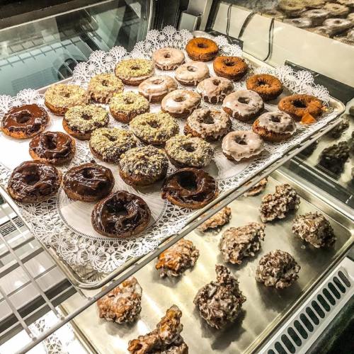 A display of assorted donuts and pastries on a decorative tray, featuring various toppings and flavors.