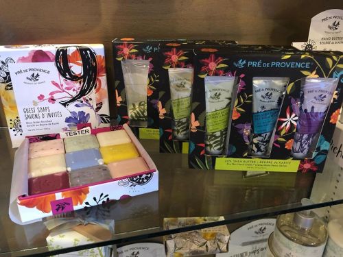 A display of guest soaps and hand creams from Prè de Provence, featuring colorful packaging and a variety of scents.
