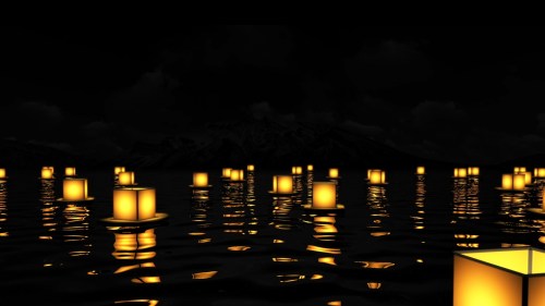 Floating lanterns illuminate a dark lake, reflecting softly on the water's surface against a mountainous backdrop.