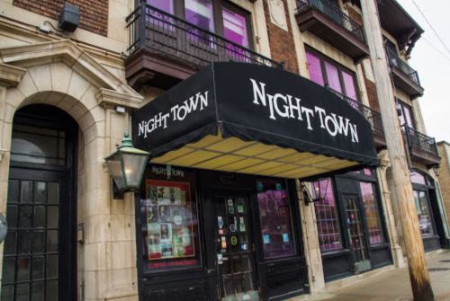 Exterior of Nighttown, a building with a black awning, large windows, and a vintage lamp post.
