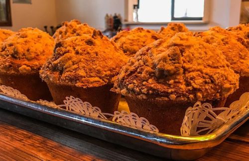 A tray of freshly baked muffins with a crumbly topping, arranged neatly and ready to be served.