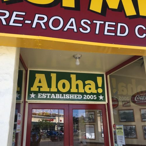 Sign on a storefront reads "Aloha! ESTABLISHED 2005" with bright colors and a welcoming design.