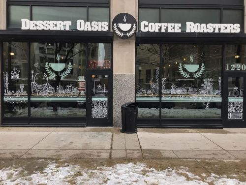 Exterior of Dessert Oasis Coffee Roasters, featuring decorative window art and a snowy sidewalk.