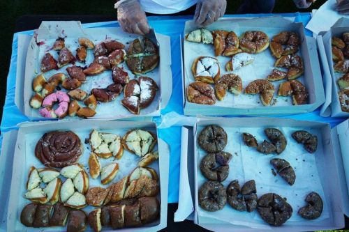 A variety of colorful donuts displayed in boxes, featuring different flavors and toppings.