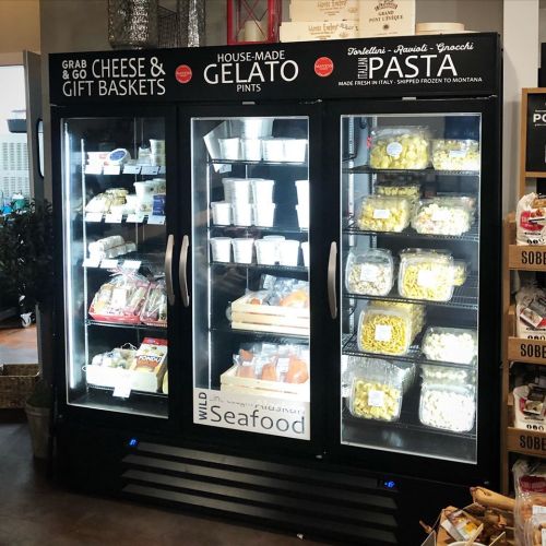 A display case filled with cheese, gelato pints, pasta, and seafood products in a grocery store.