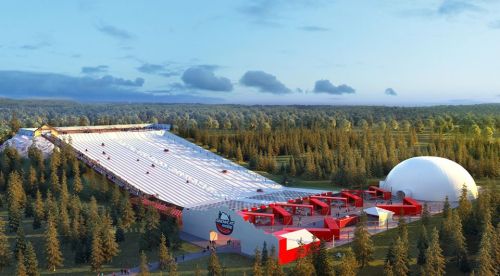 A large indoor ski slope surrounded by trees, featuring a white dome and red structures for skiing activities.